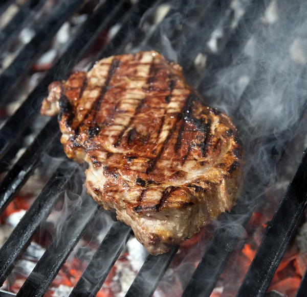 Bife de carne cozinhando em uma grelha de chama aberta — Fotografia de Stock