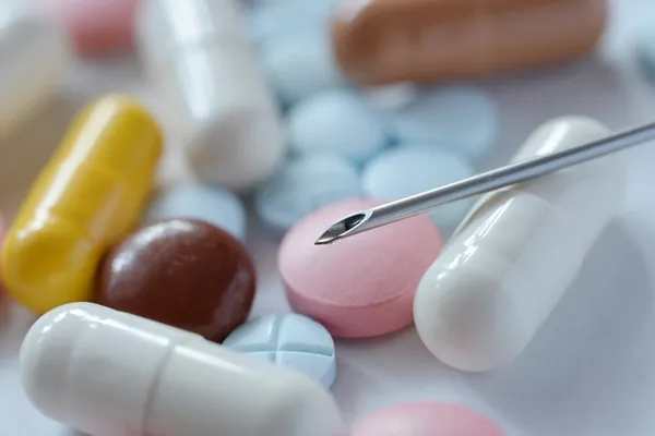 Siringa su uno sfondo di pillole — Foto Stock