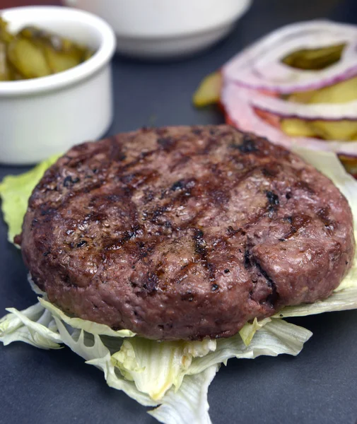 Open burger with lettuce leaves — Stock Photo, Image