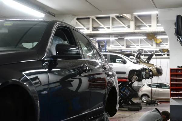 Carro em garagem com equipamento especial preparado para reparação — Fotografia de Stock