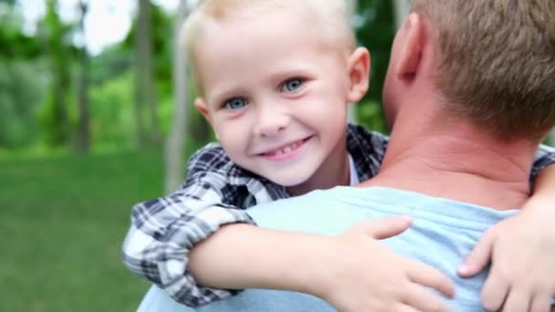 Szczęśliwy biały blondyn obejmuje swojego ojca. Portret szczęśliwego dziecka. Rodzina w parku. Edukacja, troska. przytulając tatę. ojcostwo i koncepcja miłości — Wideo stockowe