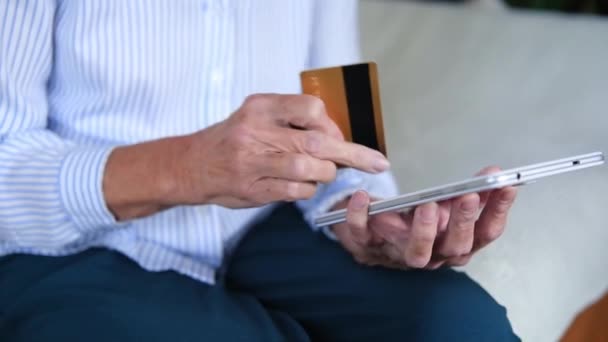 Mulheres idosas mãos closeup usando tablet segurando cartão de crédito comprar na internet. Fazer pagamentos, desfrutar de transferência instantânea de dinheiro fácil. Compre remotamente a partir de casa entrega conforto rápido. conceito de serviços — Vídeo de Stock