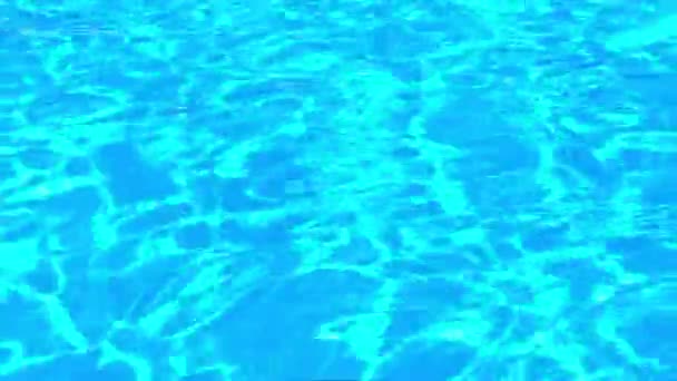 Povrch bazénu s průzračnou modrou vodou se světelnými odrazy. — Stock video