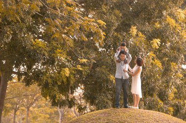 Asyalı genç aile sonbaharda dışarıda eğleniyor