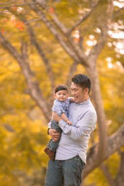 Asyalı genç aile sonbaharda dışarıda eğleniyor