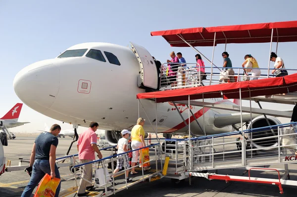 Passeggeri che vanno su una scala in aereo. Aeroporto Sharjah Fotografia Stock