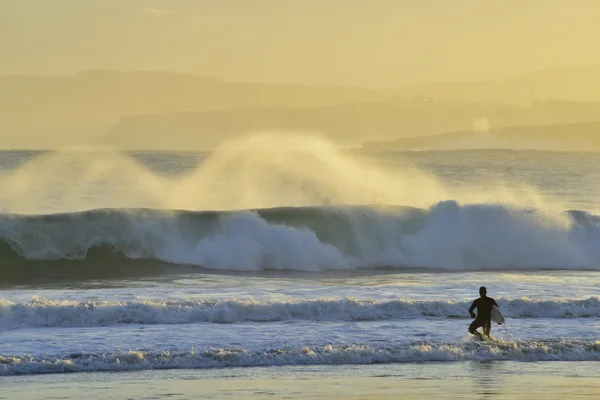 Surfař silueta proklouzává do vody — Stock fotografie