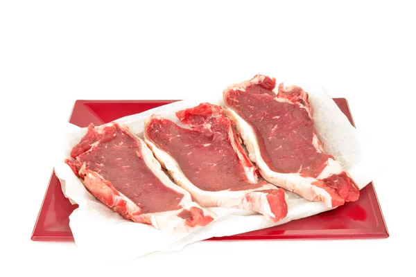 Steaks in red tray isolated — Stock Photo, Image