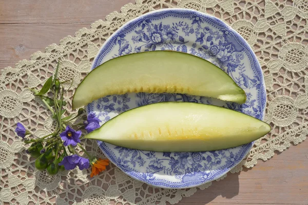 Melon slices on a plate on wooden table — Stock Photo, Image