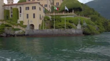 Tremezzina, Como, Lombardy, İtalya. 15 Temmuz 2021. Villa Balbianello 'yu geçiyoruz. Star Wars ve James Bond gibi filmler burada çekildi. Gri, bulutlu bir yaz günü. Editör 4K klibi
