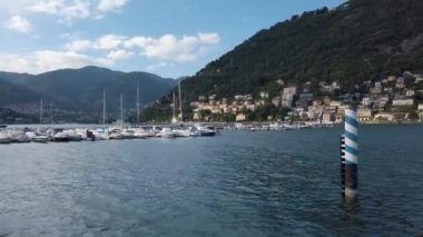 Como Gölü 'ndeki Como marinasında kamera var. Arka planda dağlar var ve Como ve Brunate arasındaki füniküler görülebilir. Güzel, güneşli bir yaz günü..