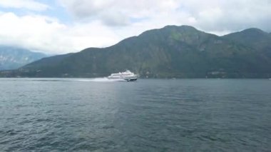 Como Gölü 'nde yelken açarken, diğer yönden gelen hızlı bir turist feribotundan kısa bir atış. Hava bulutlu, bulutlu bir yaz günü. 4K