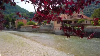 İtalya, Lombardy 'deki Como Gölü' ndeki Bellano şehrindeki Pioverna Nehri 'nin video klibi. Video akıntıya karşı çekildi. Nehrin arkasında evler ve tepeler var. Güzel, güneşli bir yaz günü.