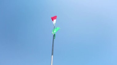 İtalyan bayrağı ve rüzgarda dalgalanan Lombardy bayrağı, güzel mavi bir gökyüzünde, birkaç beyaz bulutla. Güneşli güzel bir yaz günü. İtalya 'nın Balkonunda çekilmiş. Yavaş çekim 4K