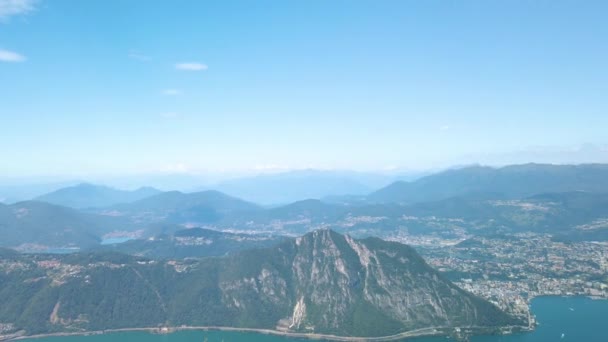 从意大利巴尔科尼山顶俯瞰卢加诺湖 卢加诺市和其他城市的壮丽景色 摄像机从左向右倾斜 视野深入瑞士 一直延伸到瑞士阿尔卑斯山 从边境的意大利一侧开枪 — 图库视频影像