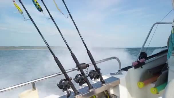 3本の釣り竿がスピナーで引っ掛けられ 釣りの準備ができていた ロッドは小さな漁船の列に並んでいます 天気の良い春の日です — ストック動画
