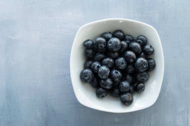 Kırsal bir arka planda lezzetli, lezzetli yaban mersini. Yemek fotoğrafçılığı. Mesajın için böğürtlenlerin etrafında boşluk bırak.