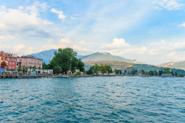 The beautiful Garda lake in Italy, seen from the Piazza ill Novembre square in the city of Riva del Garda, Trentino, Italy. It is a beautiful summer day, with a little bit of clouds.