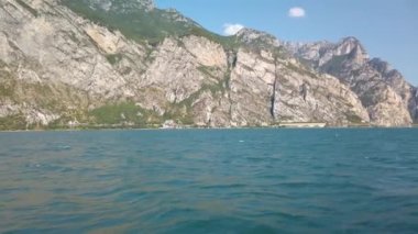 İtalya 'daki güzel Garda Gölü' nün üzerinde turistik bir feribottan görülmüş. Arka planda Riva del Garda şehri var. Çok güzel bir yaz günü, biraz bulutlu. 4K stok video