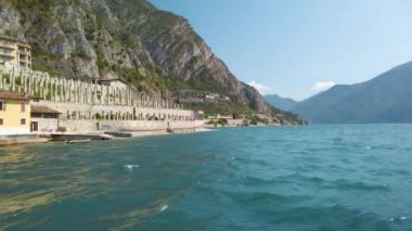 Limone şehrinden Garda gölü kıyısına doğru yelken açıyorlar. Turist feribotundan vurulmuş. Güneşli güzel bir yaz günü. 4K stok video