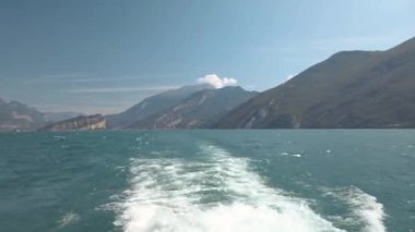İtalya 'daki güzel Garda Gölü' nde yelken açan bir turist feribotunun ardından serpinti. Çok güzel bir yaz günü, biraz bulutlu. 4K stok video