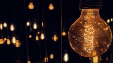 Eski moda tungsten lambaları siyah arka planda yanıp sönüyor. Yavaş çekim 4K.