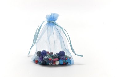 Blue cloth bag filled with glass beads for jewelry clipart