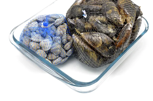 Mussels and clams in two net bags on glass bowl — Stock Photo, Image