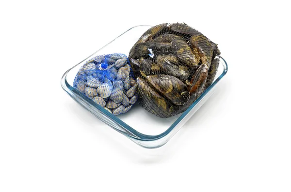 Mussels and clams in two net bags on glass bowl — Stock Photo, Image