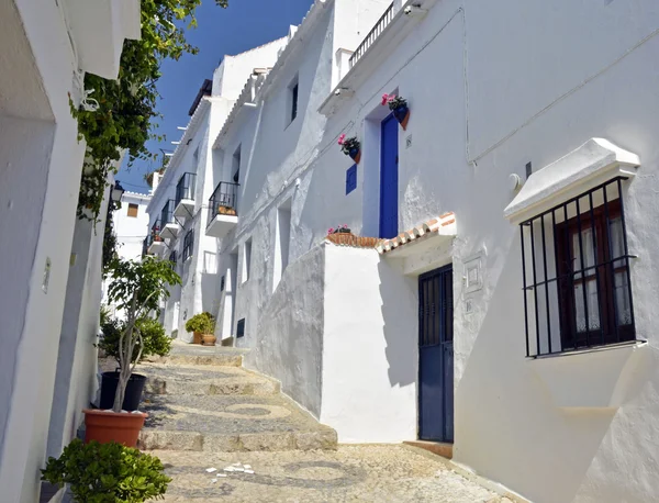 Moradias ao longo de uma típica rua da aldeia caiada de branco, Frigiliana, Andaluzia — Fotografia de Stock