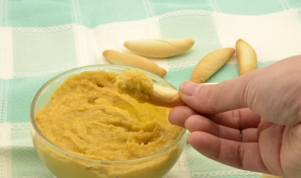 Woman hand trying humus — Stock Photo, Image