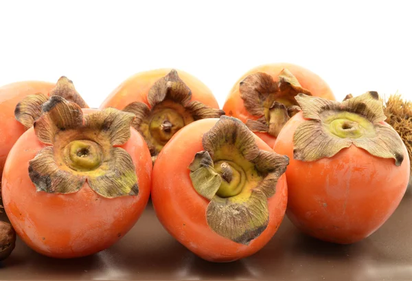 Persimmons em placa marrom — Fotografia de Stock