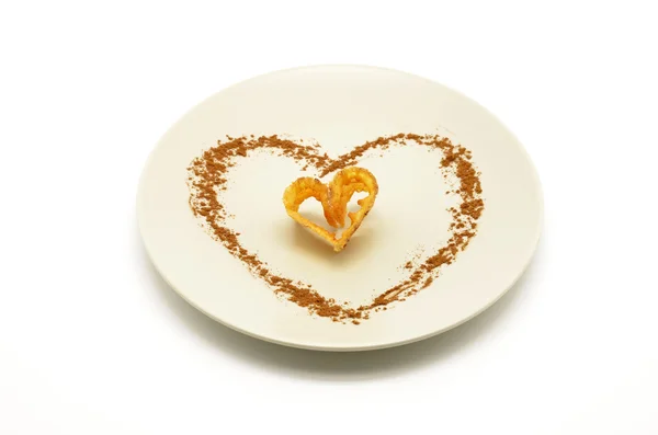 Тарелка с кусочком жареного цветка, украшенного корицей в форме сердца — стоковое фото