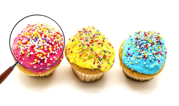 Pink cupcake view through magnifying glass — Stock Photo, Image