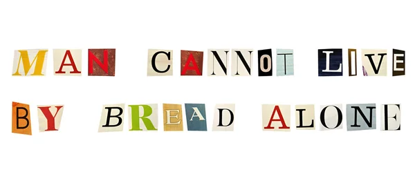 O provérbio Man Cannot Live By Bread Alone formado com letras de revista sobre fundo branco — Fotografia de Stock