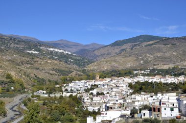 View of white village with the Sierra Nevada mountains to the rear, Cadiar, Las Alpujarras, Granada Province, Spain. clipart