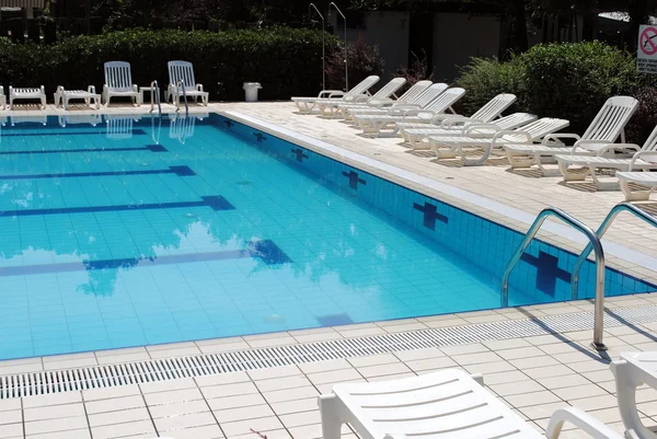 Piscina lípida y tumbonas blancas sin —  Fotos de Stock