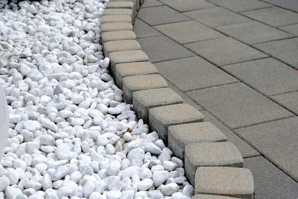 Bloemenrand bed gemaakt van kiezelstenen en stenen — Stockfoto