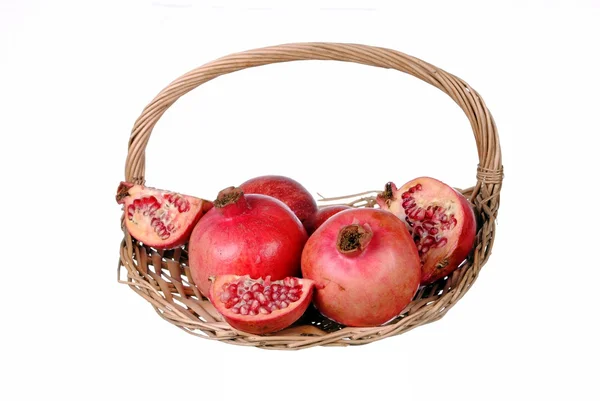 Red pomegranates in a straw basket — Stock Photo, Image