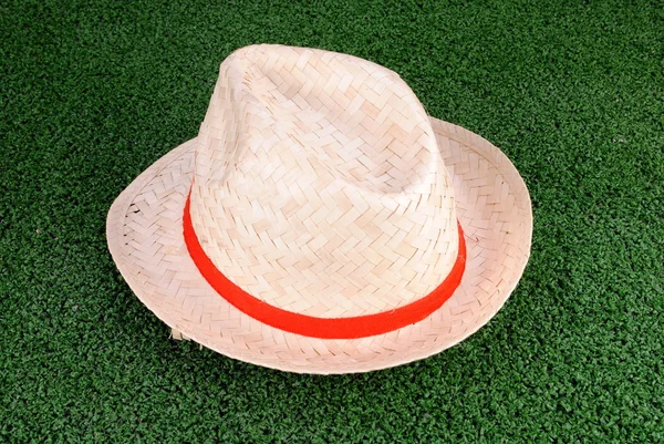 Hat made of straw on a green grass background — Stock Photo, Image