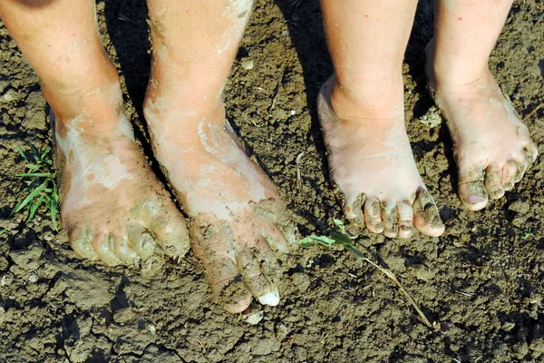 Kinderfüße im Garten nach Regen Stockbild