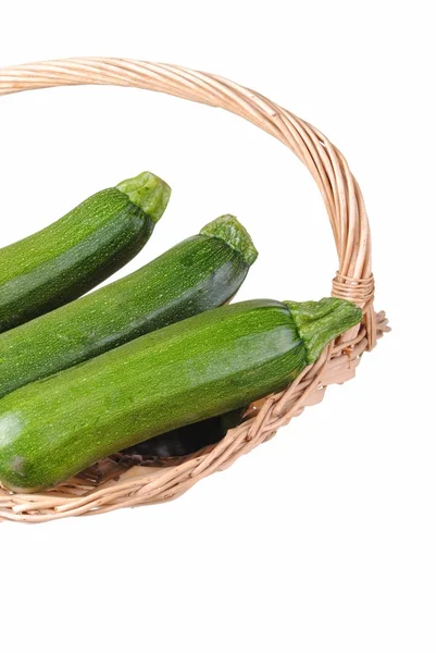 Organic courgette in a straw basket, isolated on white — Stock Photo, Image
