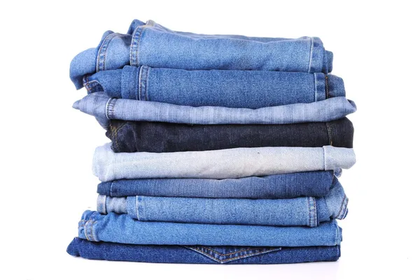 Empilement de différents types de jeans bleus, sur fond blanc — Photo