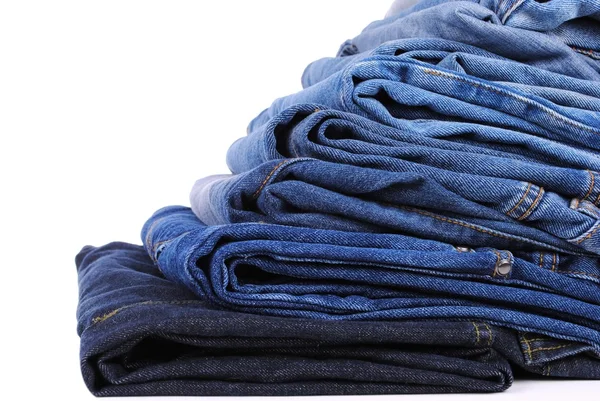 Pilha de diferentes tipos de jeans azuis, em fundo branco — Fotografia de Stock