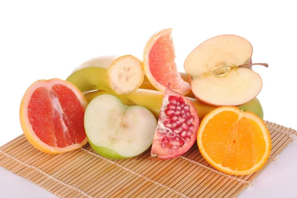 Tranches de fruits différents sur un tapis de place en bambou — Photo