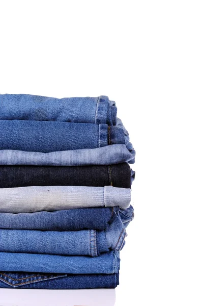 Pilha de diferentes tipos de jeans azuis, em fundo branco — Fotografia de Stock