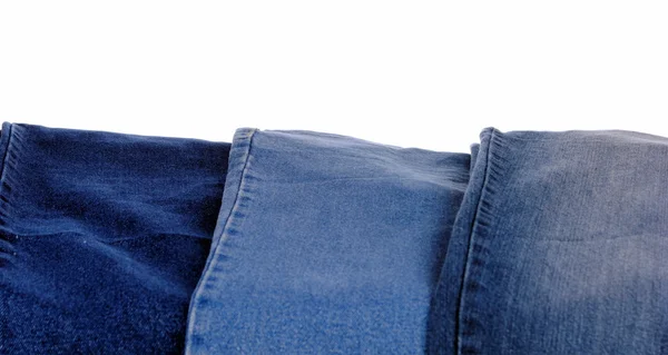 Pilha de diferentes tipos de jeans azuis, em fundo branco — Fotografia de Stock