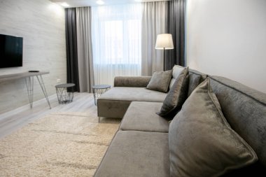 Odanın bir kısmında bej renkli bir kanepe var..