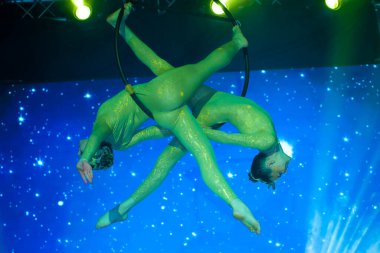 Sirk aktris akrobat performansı. İki kız hava halkasında akrobatik elementler icra.