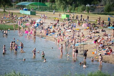 25 Temmuz 2021 Belarus, Gomil. Gölün kıyısında bir sahil. Sıcak bir günde sahilde bir sürü insan var..